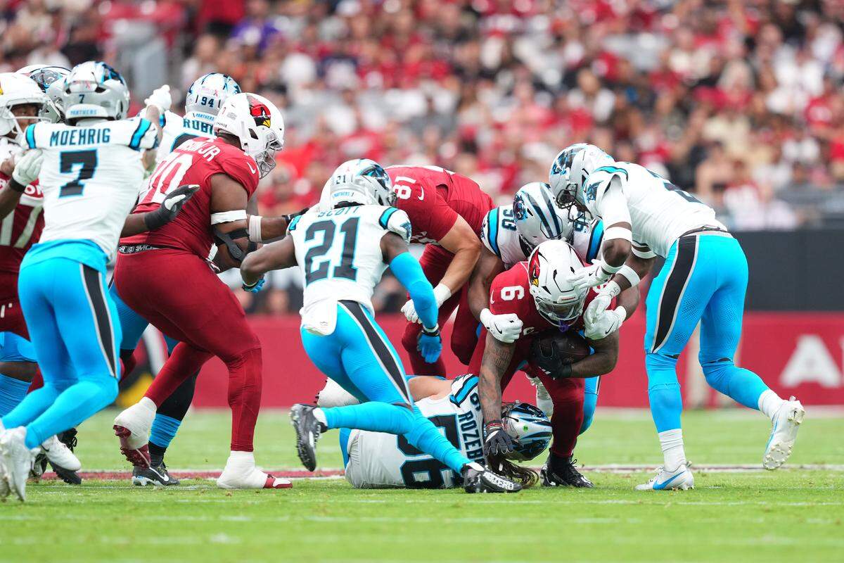 Arizona Cardinals running back James Conner (6) dives carrying the ball against Carolina Panthers linebacker Christian Rozeboom (56) during the first quarter at State Farm Stadium in Glendale, AZ on Sunday, Sept. 14, 2025.