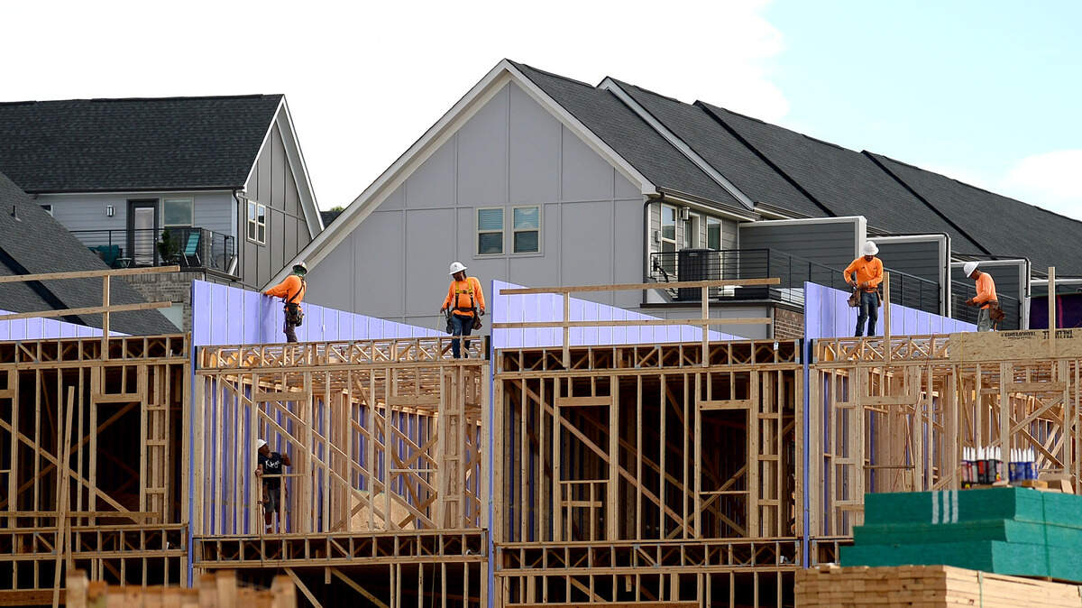 Construction workers work on another section of homes along Siegle Avenue in Charlotte, NC on July 8, 2021.