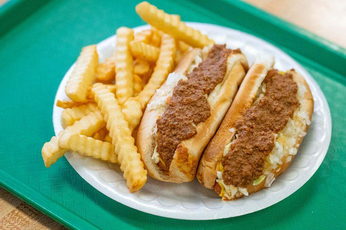 Two Green’s Lunch hot dogs served “all the way” with mustard, ketchup, homemade chili, onions, and coleslaw with a side of fries.