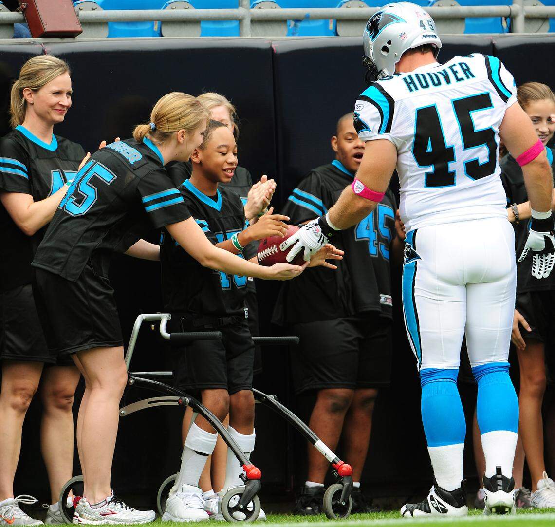 Carolina fullback Brad Hoover gives nine-year-old Chancellor Lee Adams a football before a Panthers game in 2009.  Chancellor Lee had performed during the pregame activities as part of an Allegro Foundation dance performance.