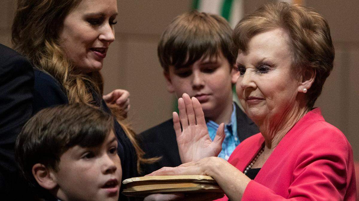Pat Cotham, right, lost her at-large seat on the Mecklenburg Board of County Commissioners on March 5, 2024 after 12 years in office. In this December 2022 photo she is being sworn in with help from her daughter Tricia Cotham and two grandsons.
