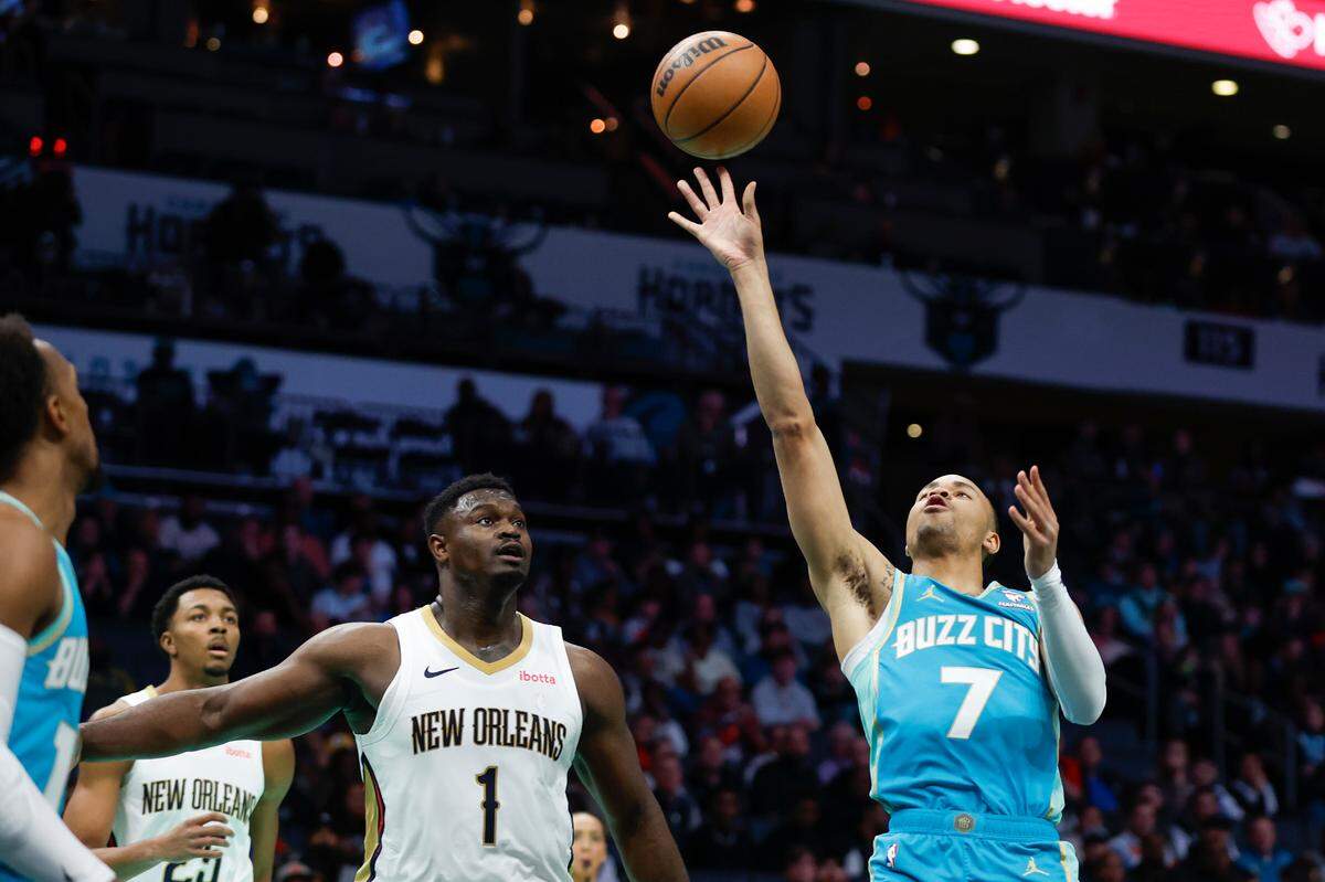 Dec 15, 2023; Charlotte, North Carolina, USA; Charlotte Hornets guard Bryce McGowens (7) shoots against New Orleans Pelicans forward Zion Williamson (1) during the first quarter at Spectrum Center.