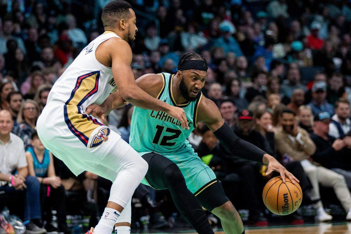 Jan 25, 2025; Charlotte, North Carolina, USA; Charlotte Hornets forward Josh Okogie (12) drives against New Orleans Pelicans guard CJ McCollum (3) during the second quarter at Spectrum Center. Mandatory Credit: Scott Kinser-Imagn Images