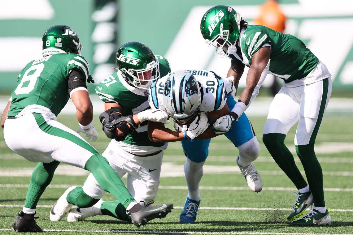 Carolina Panthers running back Chuba Hubbard (30) is tackled by New York Jets linebacker Kiko Mauigoa (51) and cornerback Sauce Gardner (1) in the second quarter on Sunday in New Jersey.