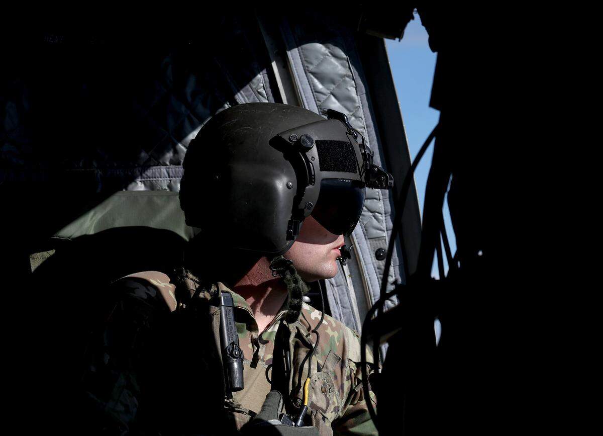 Bravo Company 1-171 crew member Ryan Venden watches for other air traffic as the team flies a mission to Western North Carolina to deliver bottled water and ready to eat meals on Thursday, Oct. 3, 2024.