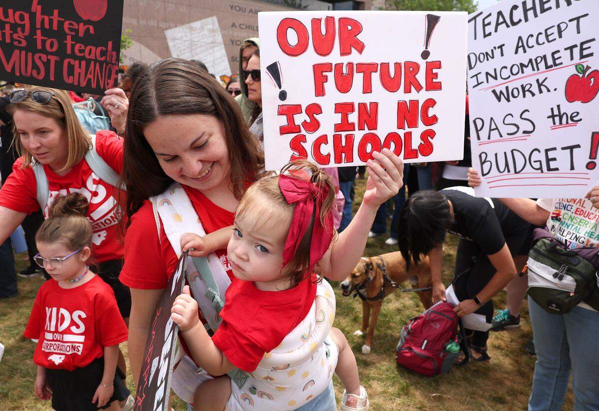 Jessica Ott and her daughter, Tallulah, were among those gathered to support teachers as they rallied and marched through downtown Raleigh, NC on Friday, May 1, 2026 The mass rally was to protest the need for more funding for public schools. Tallulah will attend Elizabeth Lane in the future.