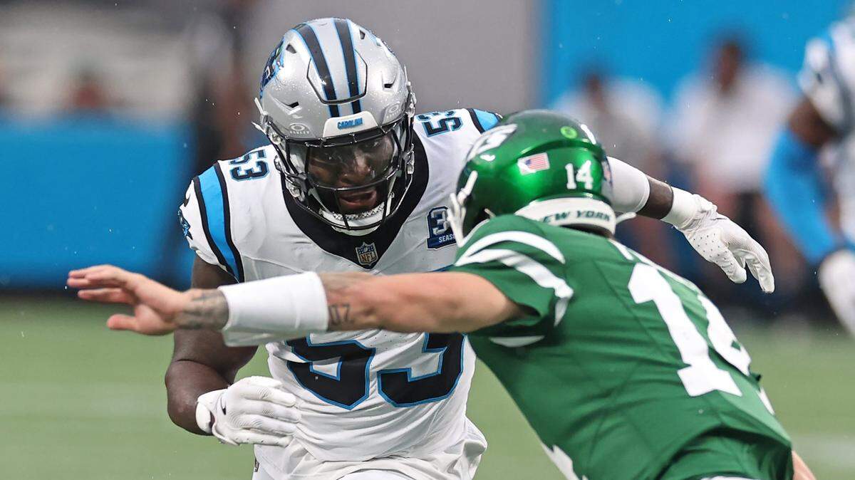Carolina Panthers linebacker Claudin Cherelus, left, looks to make the tackle on New York Jets quarterback Andrew Peasley, right, on a run during first quarter action at Bank of America Stadium in Charlotte, NC on Saturday, August 17, 2024.