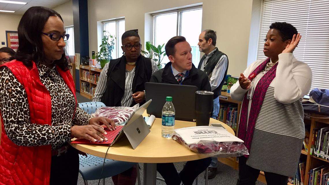 Denise Watts (right), who supervises all the principals taking part in the Harvard program, talks with principals Angela Bozeman of Druid Hills Academy, Neodria Brown of Ranson Middle and Matt Bower of Hickory Grove Elementary (l-r).