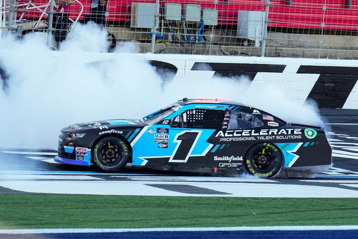 Oct 7, 2023; Concord, North Carolina, USA; NASCAR Xfinity Series driver Sam Mayer (1) takes the checkered flag and does a burn out during the Drive for the Cure 250 at Charlotte Motor Speedway Road Course.