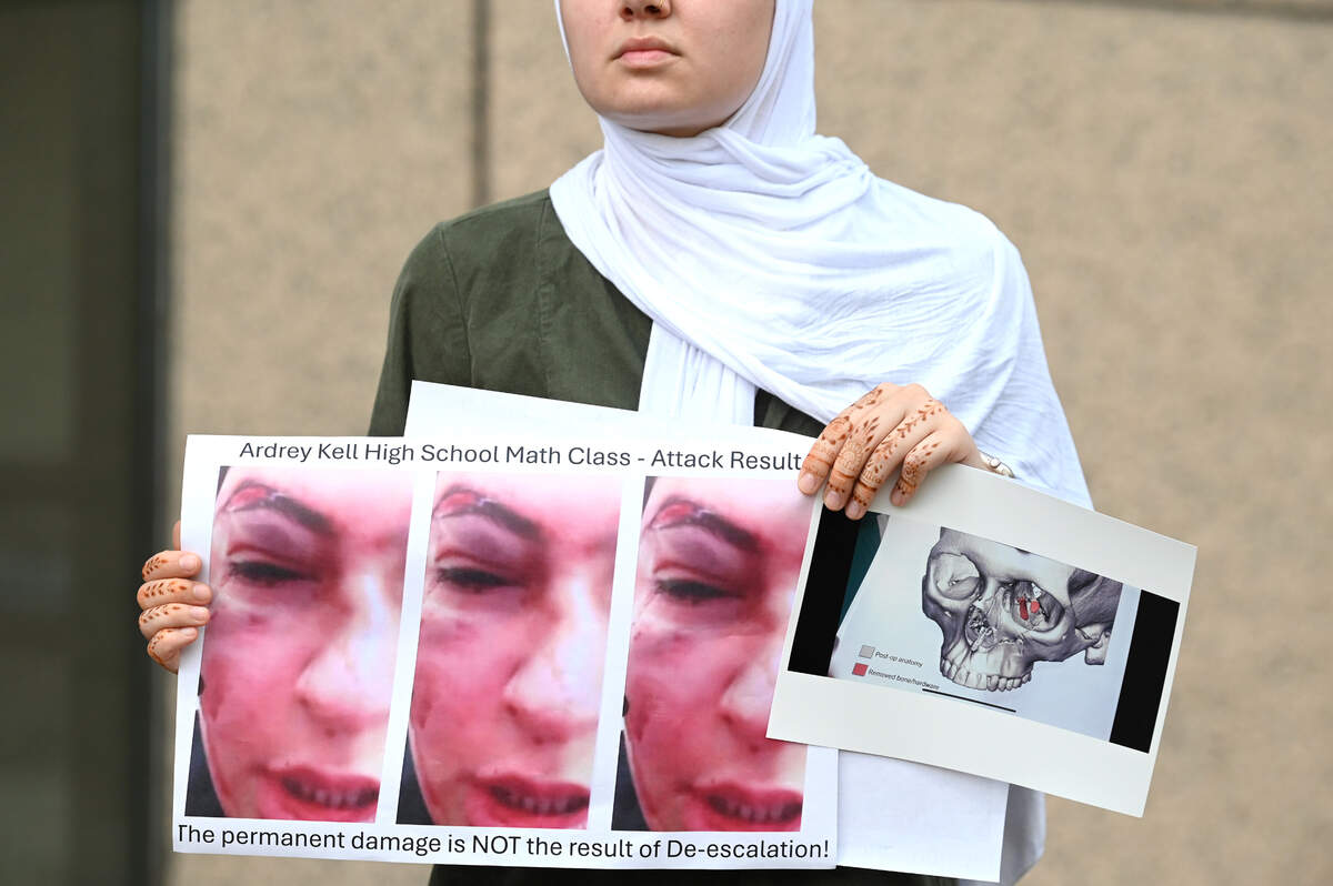 A woman at a news conference Friday holds images depicting injuries sustained by the 15-year-old female Ardrey Kell High student who was assaulted on March 7.