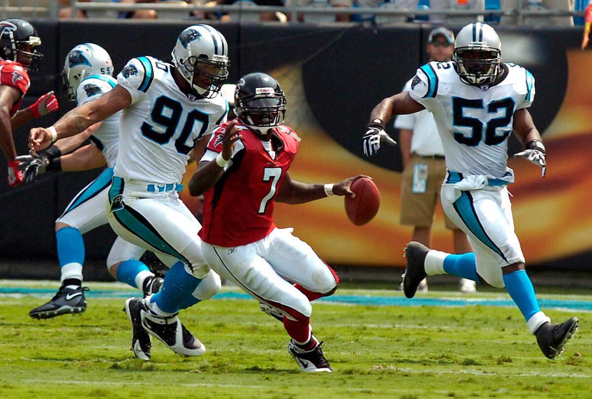 In 2006, Atlanta quarterback Michael Vick (7) eludes Panthers Julius Peppers (90) and Chris Draft (52). Peppers would later call Vick the most difficult opponent he has ever raced, in part because VIck was “faster than your whole defense.”