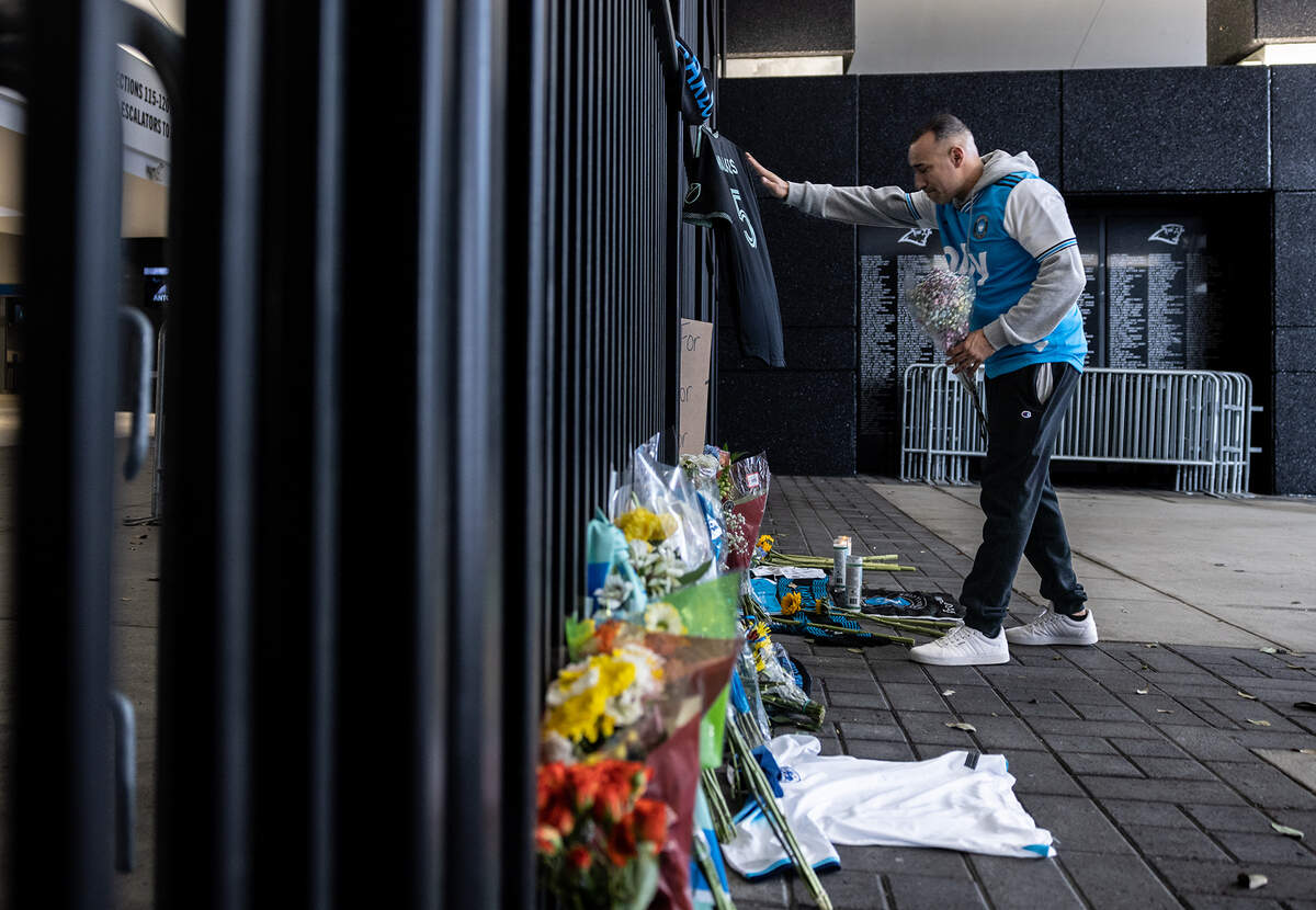 A mourner lays flowers down in front of a memorial during a vigil for Charlotte FC defender Anton Walkes Charlotte, N.C., on Thursday, January 19, 2023.