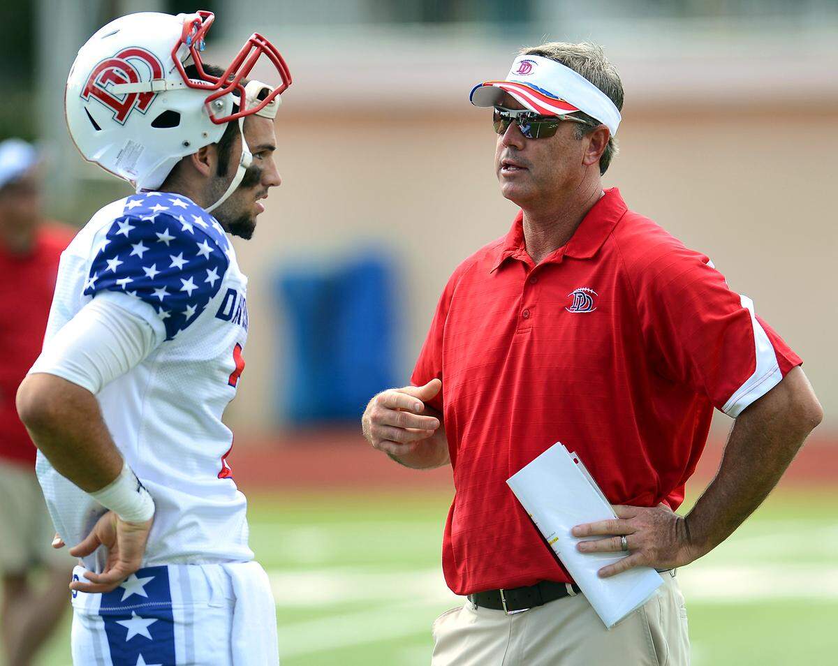 Davidson Day quarterback Will Grier, left, and head coach Chad Grier talk before a 2013 game against Providence Day.