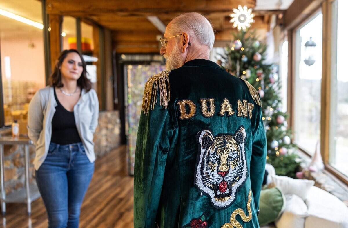 Jennifer Swenk, owner of Sparta Candle Co., looks at her dad, Duane, as he shows off the blazer she made him.