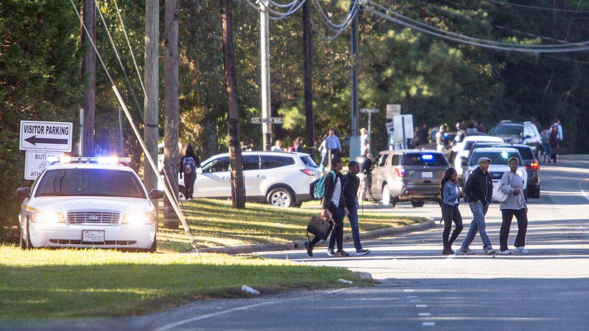 Parents walk to pick up their children outside Butler High School after a school shooting last month.