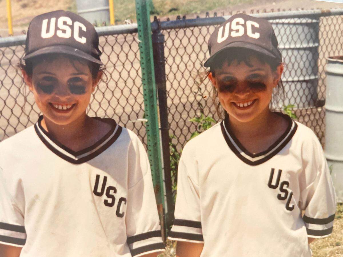 Meghan Fillnow, left, with her twin sister Kelly, photographed at age 9, when they played for a girls softball team in Upper St. Clair outside of Pittsburgh, Pennsylvania.