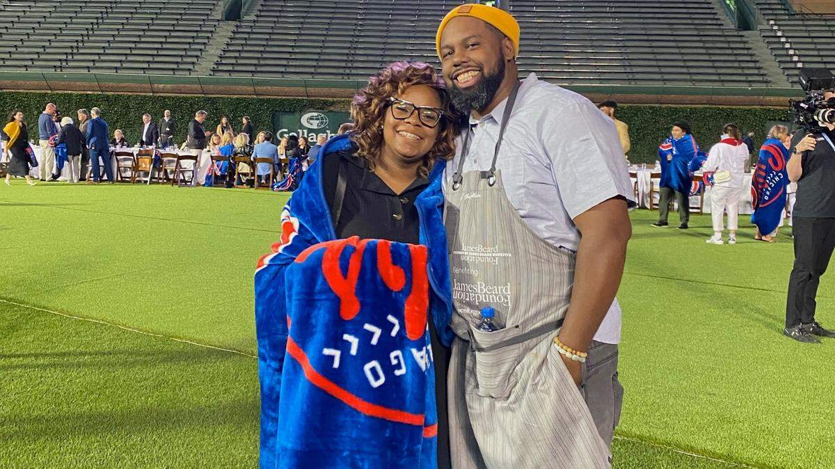 BayHaven Restaurant Group founders Subrina Collier and chef Gregory Collier stand in the outfield of Wrigley Field after the inaugural Friends of James Beard Benefits Stadium Chef Series.