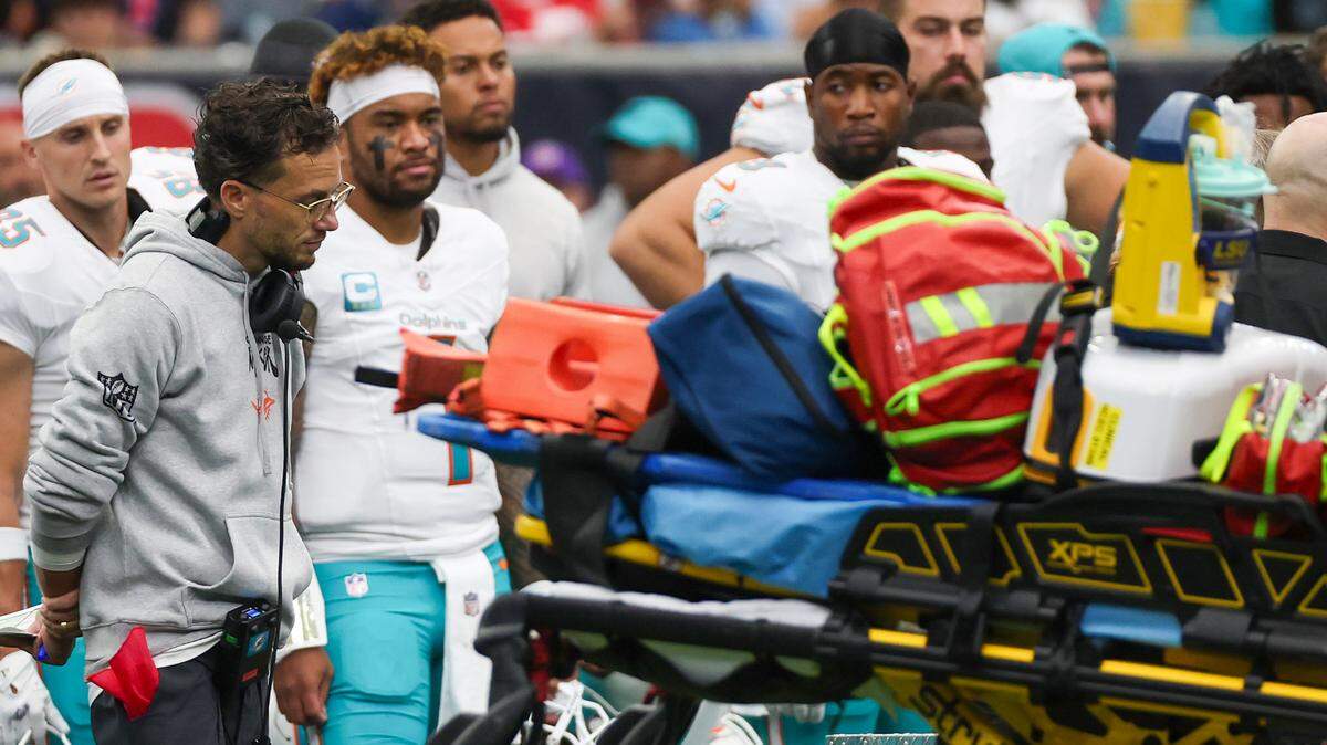 Dec 15, 2024; Houston, Texas, USA; Miami Dolphins head coach Mike McDaniel and quarterback Tua Tagovailoa (1) look on as the medical team works on wide receiver Grant DuBose (88) (not pictured) after he was injured when he was tackled by Houston Texans safety Calen Bullock (21) (not pictured) in the third quarter at NRG Stadium.