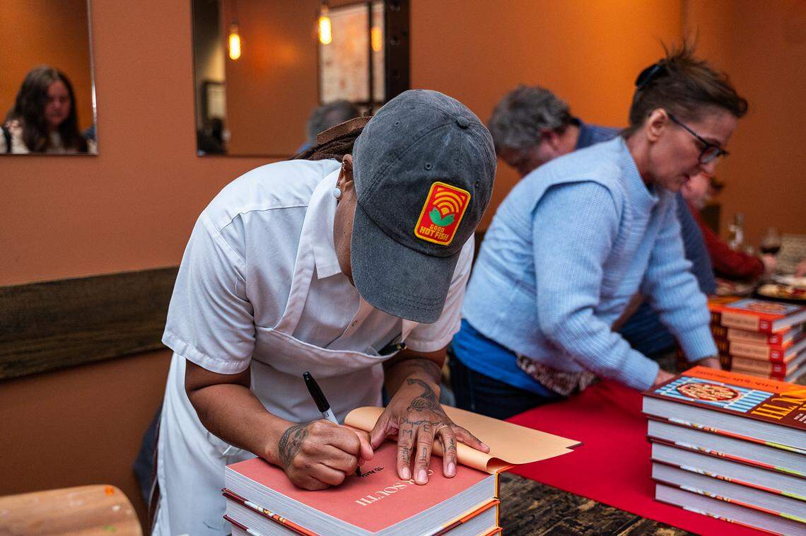 Chef Ashleigh Shanti signs copies of her new book “Our South: Black Food Through My Lens” at a Pintxo Party relief dinner hosted at Cúrate.