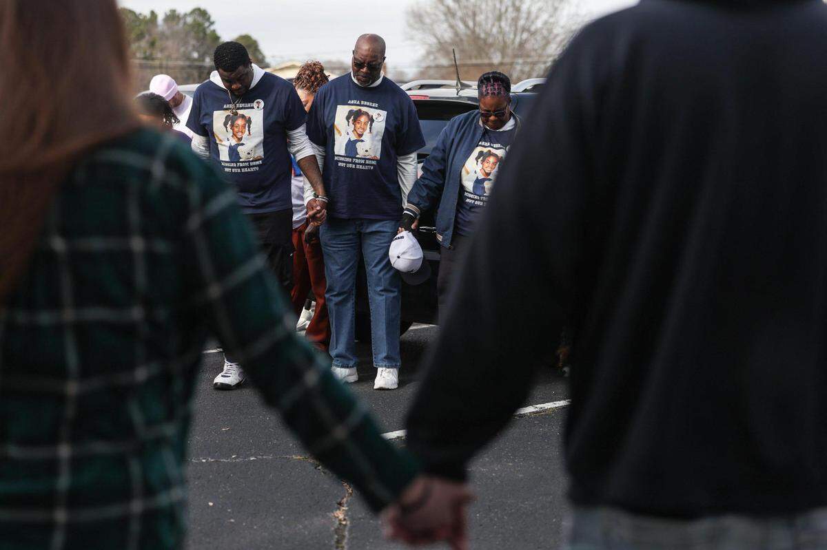 Friends and family pray before beginning a march on Falston Road to commemorate the 25th year of Asha Degree going missing in Shelby, NC on Saturday, February 8, 2025.