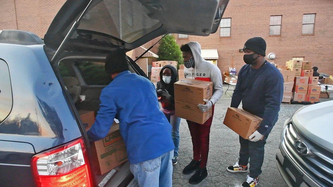 Volunteers load up a van with food during a Loaves & Fishes mobile food pantry distribution site on Tuesday, Nov. 24, 2020.