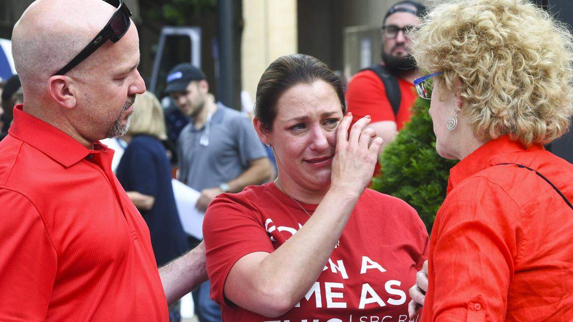 Jules Woodson, center, is comforted by her boyfriend during a demonstration outside the Southern Baptist Convention’s annual meeting in Birmingham, Ala. in 2019. Woodson spoke through tears as she described being abused sexually by a Southern Baptist minister.