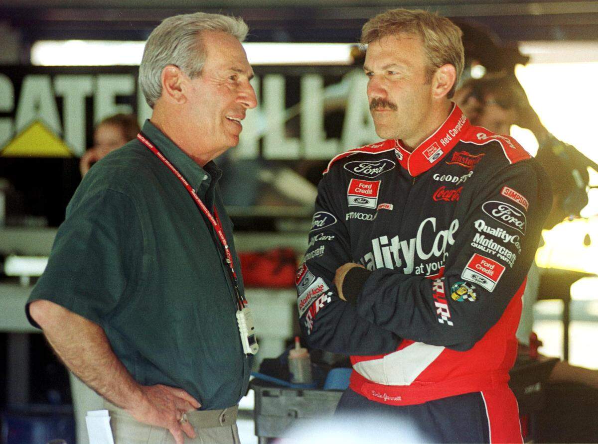2/5/99 Former NASCAR driver Ned Jarrett talks with his son, Dale in the garage area at Daytona International Speedway Friday afternoon.