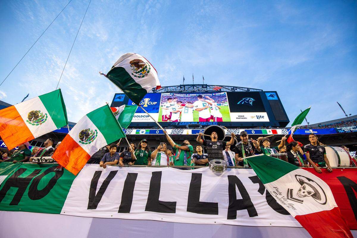Members of Pancho Villa’s Army, a fan club for Mexico’s national soccer team, bang their drums and wave the Mexican flag during the Group A match against Martinique at Bank of America Stadium in Charlotte on Sunday.
