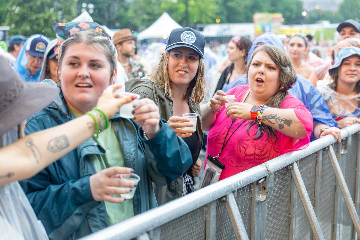 Fans share shots in the rain at Lovin’ Life Music Fest.