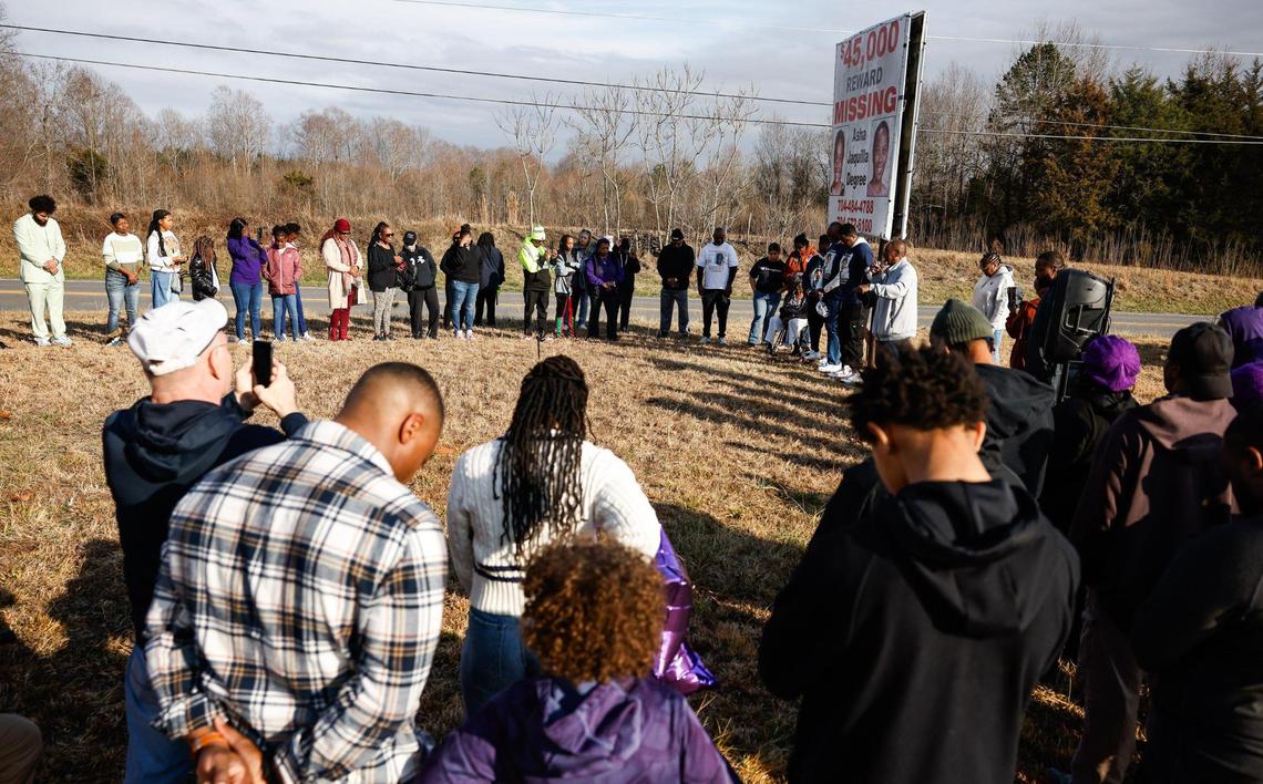 Friends, family and supporters pray together at the area where 9-year-old Asha Degree was last seen, near the woods off of North Carolina Highway 18, during a walk to commemorate the 25th year of her disappearance.