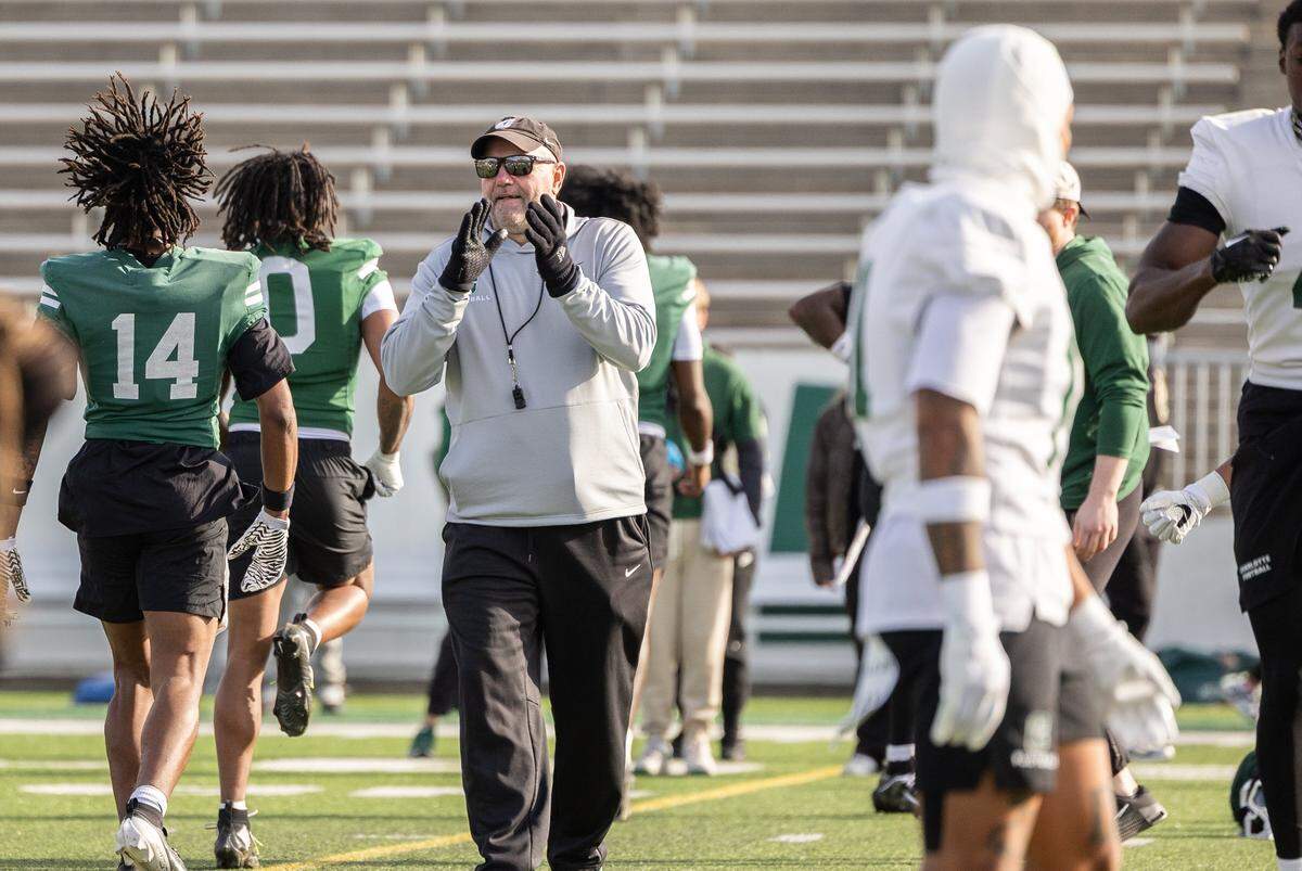 Charlotte 49ers Tim Albin watches players warm up during Charlotte 49ers open spring football practice at Jerry Richardson Stadium in Charlotte, N.C., on Tuesday, March 24, 2026.