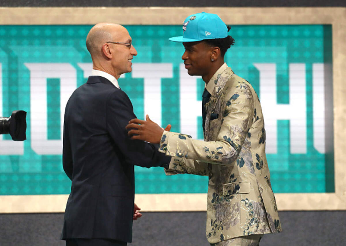 Shai Gilgeous-Alexander poses with NBA Commissioner Adam Silver after being drafted 11th overall by the Charlotte Hornets during the 2018 NBA Draft.