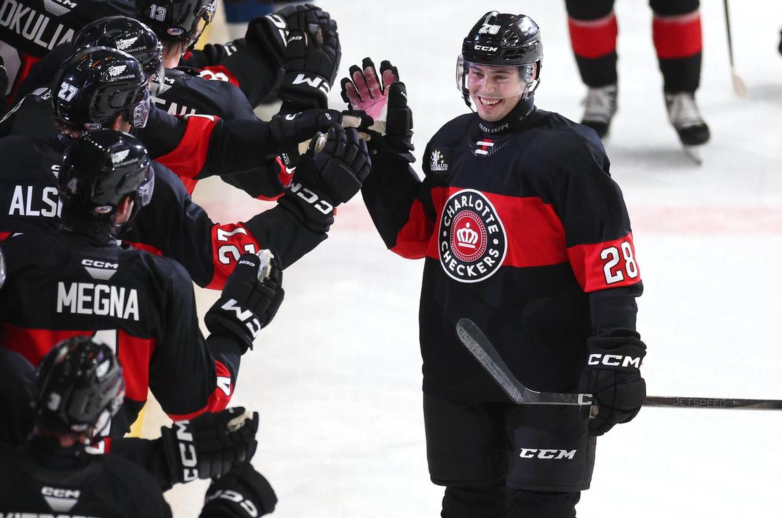 Charlotte Checkers Aidan McDonough, right, slaps hands with his teammates after scoring his second goal of the night against the Cleveland Monsters at Bojangles Coliseum in Charlotte, NC on Friday, October 18, 2024.