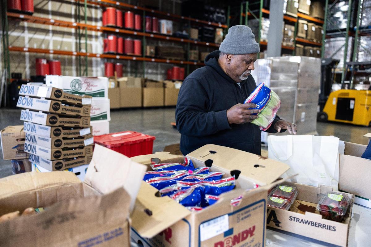 Volunteer Michael Pigford packs a bag of fresh food at the warehouse of the Nourish Up food pantry in Charlotte.