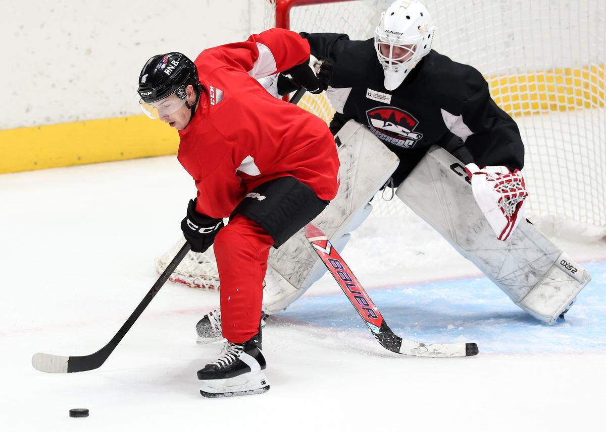 Charlotte Checkers Ben Steeves, left, controls the puck in front of the goal during practice at BoJangles Coliseum in Charlotte, NC on Thursday, October 9, 2025.