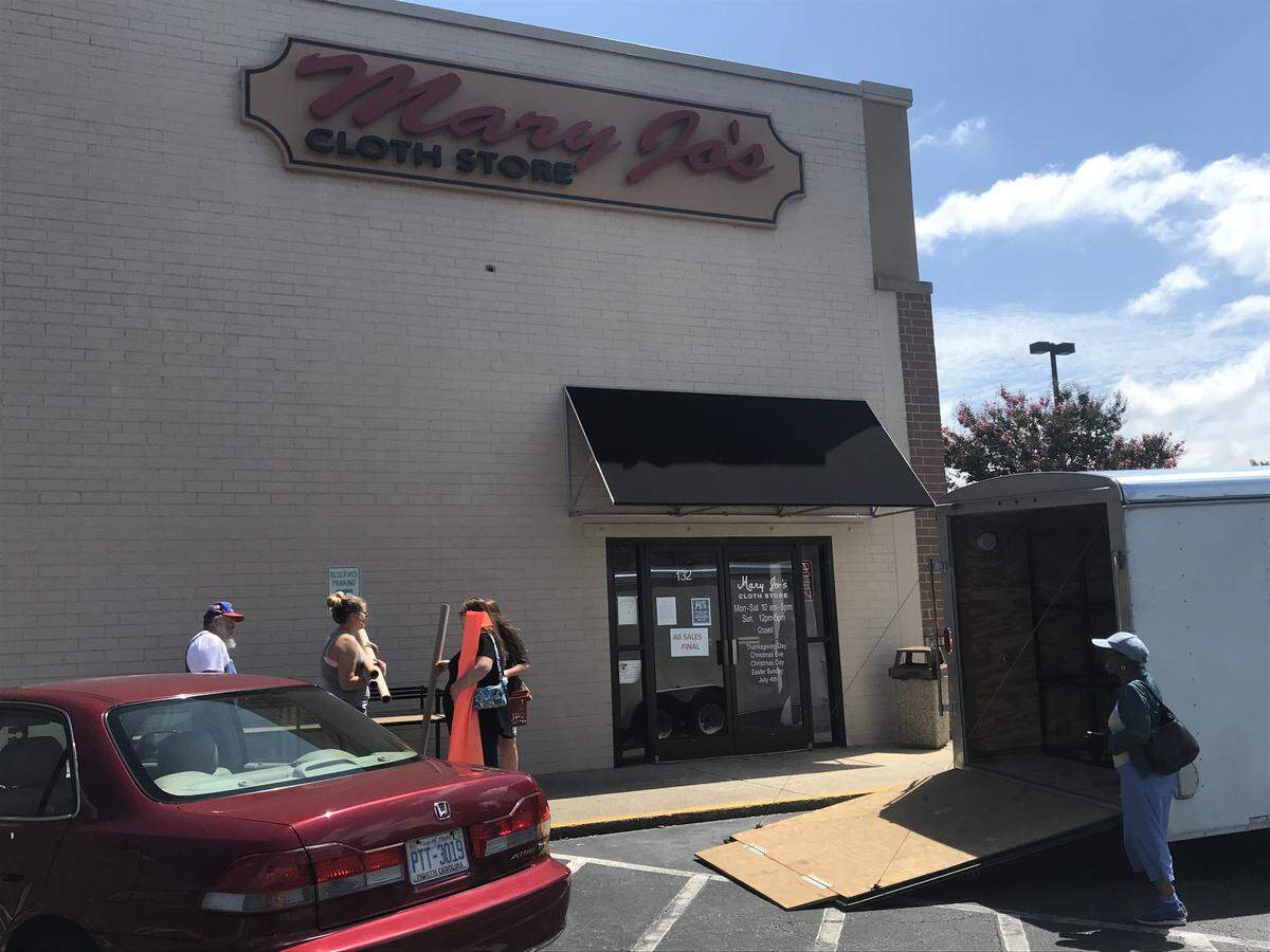 Customers haul out fabric and fixtures during the last days of Mary Joe’s Cloth Store. The Gastonia store, which was a regional landmark, closes Aug. 31.