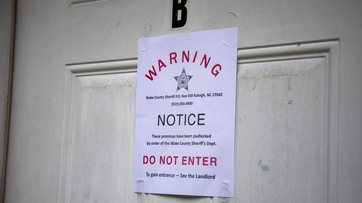 A padlock notice is taped to the door of an apartment, whose tenant was unavailable for comment, on in late August Raleigh, N.C.