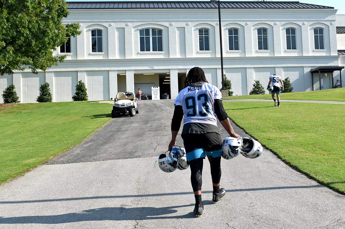 Carolina Panthers defensive tackle Gerald McCoy carries several teammates’ helmets back to the locker room following practice on Friday at Wofford College in Spartanburg. McCoy is an 11-year veteran and said he often carried helmets for teammates while playing in Tama Bay, too -- a job usually assigned to NFL rookies.
