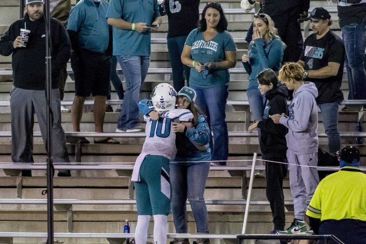 Coastal Carolina quarterback Grayson McCall (10) goes into the stands to give his aunt, Dena McCall, a hug following Coastal’s 42-38 comeback win over Troy on Dec. 12th.