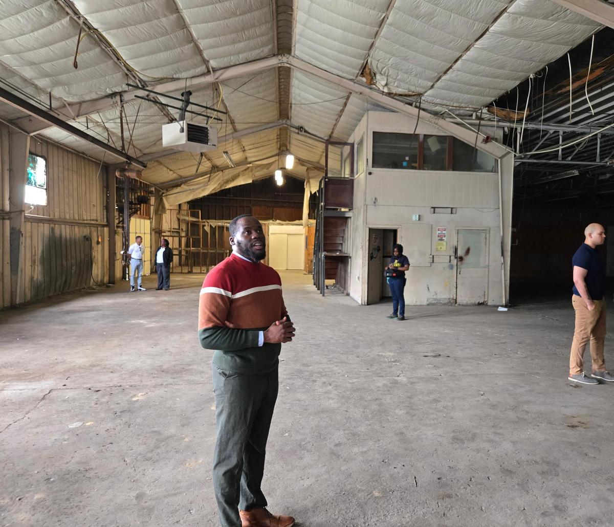 Cathay Dawkins, chairman for the Charlotte-Mecklenburg Black Chamber of Commerce, gives a tour of a warehouse space that will be used for the organization’s new Innovation Center.