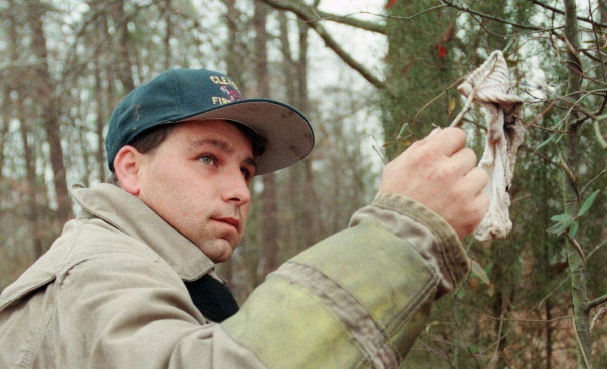 Jerry Patterson holds up a child-sized sock he found behind a tree in a trailer park just off of N.C. Highway 18 north of Shelby in rural Cleveland County on Saturday, Feb. 19, 2000. Patterson had been part of the search for 9-year-old Asha Degree for each of the previous six days.