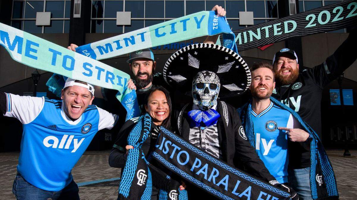 Charlotte FC super fans posing in front of Bank of America Stadium include: From left, Terry Hines, of Charlotte, Jake Carpenter, of Harrisburg, Van ONeill, of Matthews, Chico Sanchez, of Salisbury, Tyler Benson, of Charlotte, and Matt Barbee, of Greensboro.