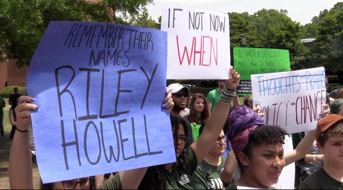 Participants at the Rally of Remembrance hold up signs as they gather near Belk Gym at UNC Charlotte on Friday, May 3, 2019, in the aftermath of the deadly classroom shooting on campus on Tuesday.