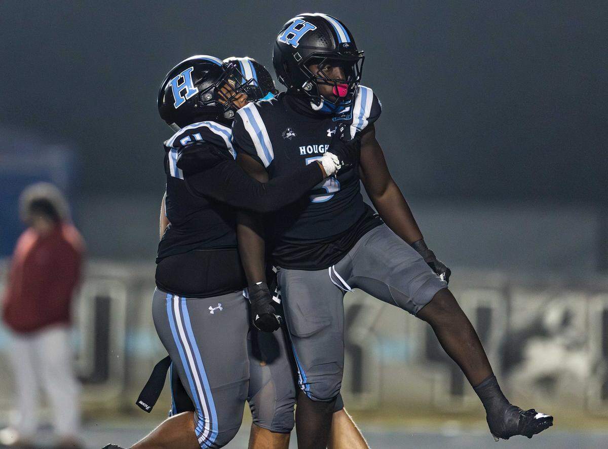 Hough Huskie Ryan Peterson (center) celebrates with his team after a sack. The Huskies would host the third round of the NCHSAA 8A playoffs against West Forsyth Friday November 21, 2025.