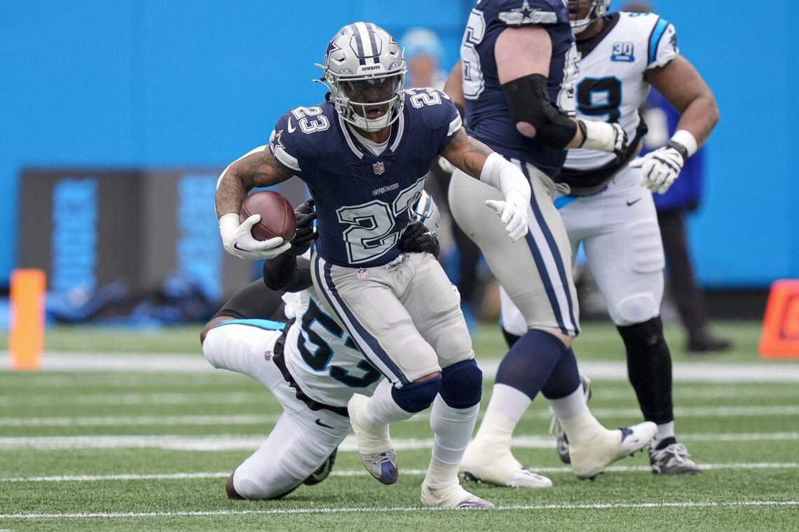 Dec 15, 2024; Charlotte, North Carolina, USA; Dallas Cowboys running back Rico Dowdle (23) runs out of a tackle by Carolina Panthers linebacker Claudin Cherelus (53) during the first quarter at Bank of America Stadium. Mandatory Credit: Jim Dedmon-Imagn Images