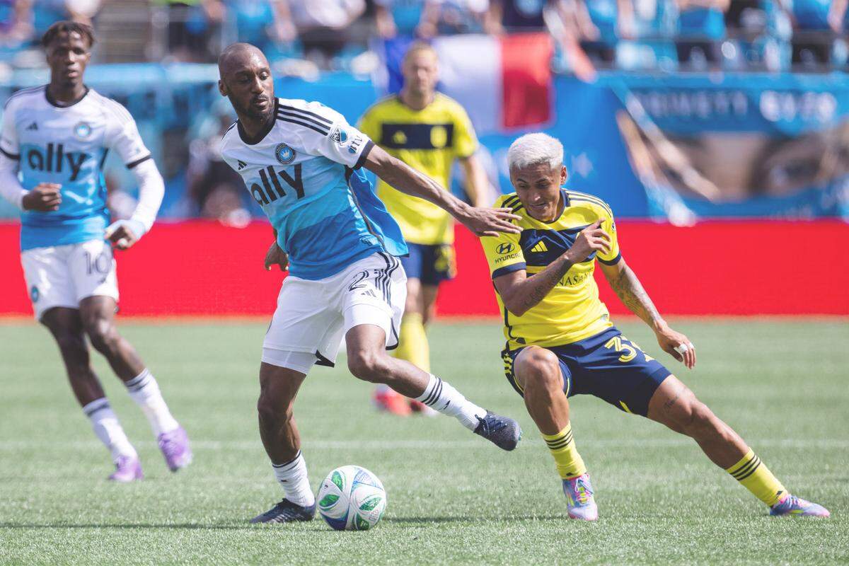 Apr 5, 2025; Charlotte, North Carolina, USA; Charlotte FC midfielder Souleymon Doumbia (20) controls the ball against Nashville SC midfielder Andy Najar (31) during the first half at Bank of America Stadium. Mandatory Credit: Scott Kinser-Imagn Images