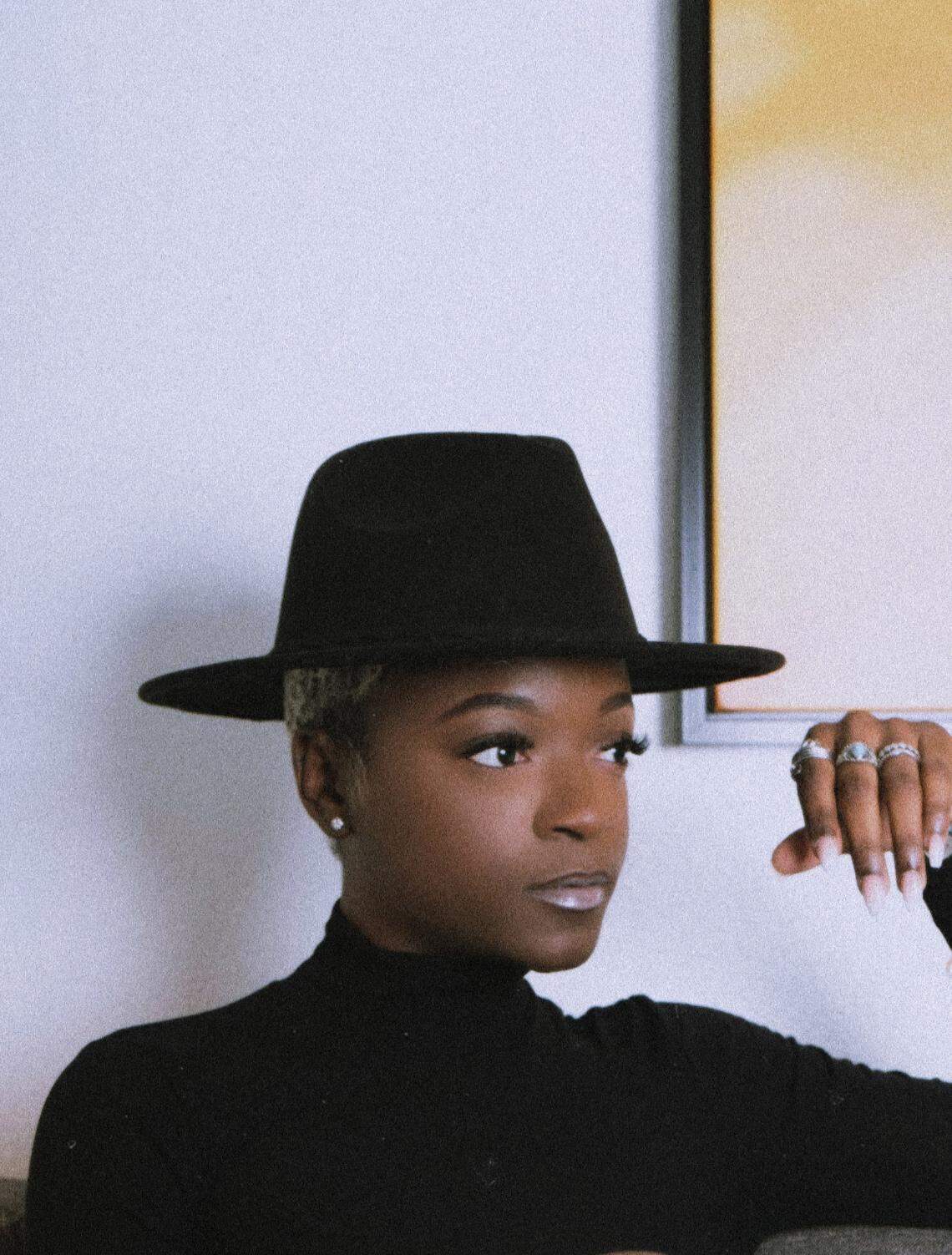 Charlotte-based fashion designer MENIA PAIGE poses for a portrait in a in black hat. Destiny Paige Reeves, aka, MENIA will present her version of Black dandyism during the “Superfine at the Gantt: Exploring Black Dandyism.” The event is an evening long program, with a red carpet, fashion show and panel taking place Friday, May 2, 2025 at the Harvey B. Gantt Center for African American Art & Culture.