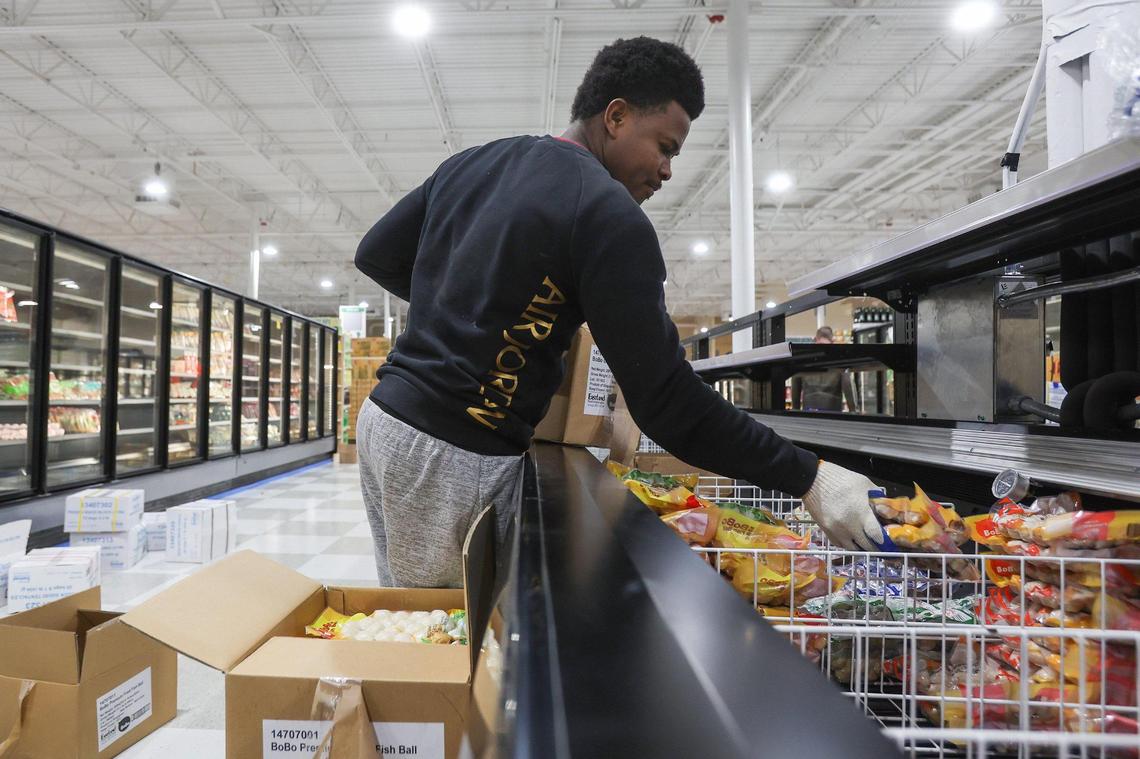 An employee stocks fish balls in the frozen section of the Super G Mart in Pineville.