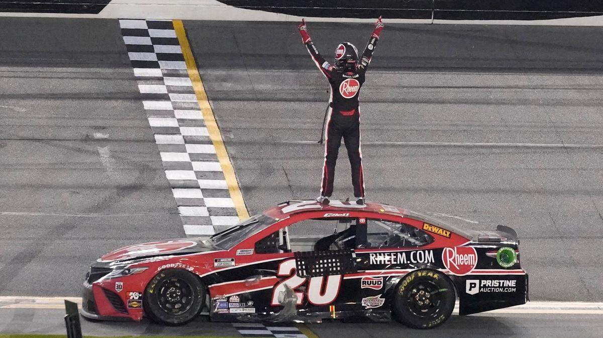 Christopher Bell stands on his car and celebrates in front of the grandstands after winning the NASCAR Cup Series road course auto race at Daytona International Speedway, Sunday, Feb. 21, 2021, in Daytona Beach, Fla. (AP Photo/John Raoux)