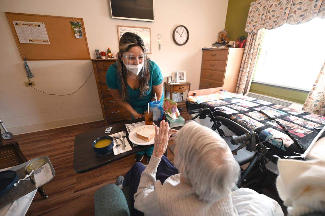 CNA Anna Foster, left, speaks with a resident at the Trinity Oaks nursing home in Salisbury, N.C.